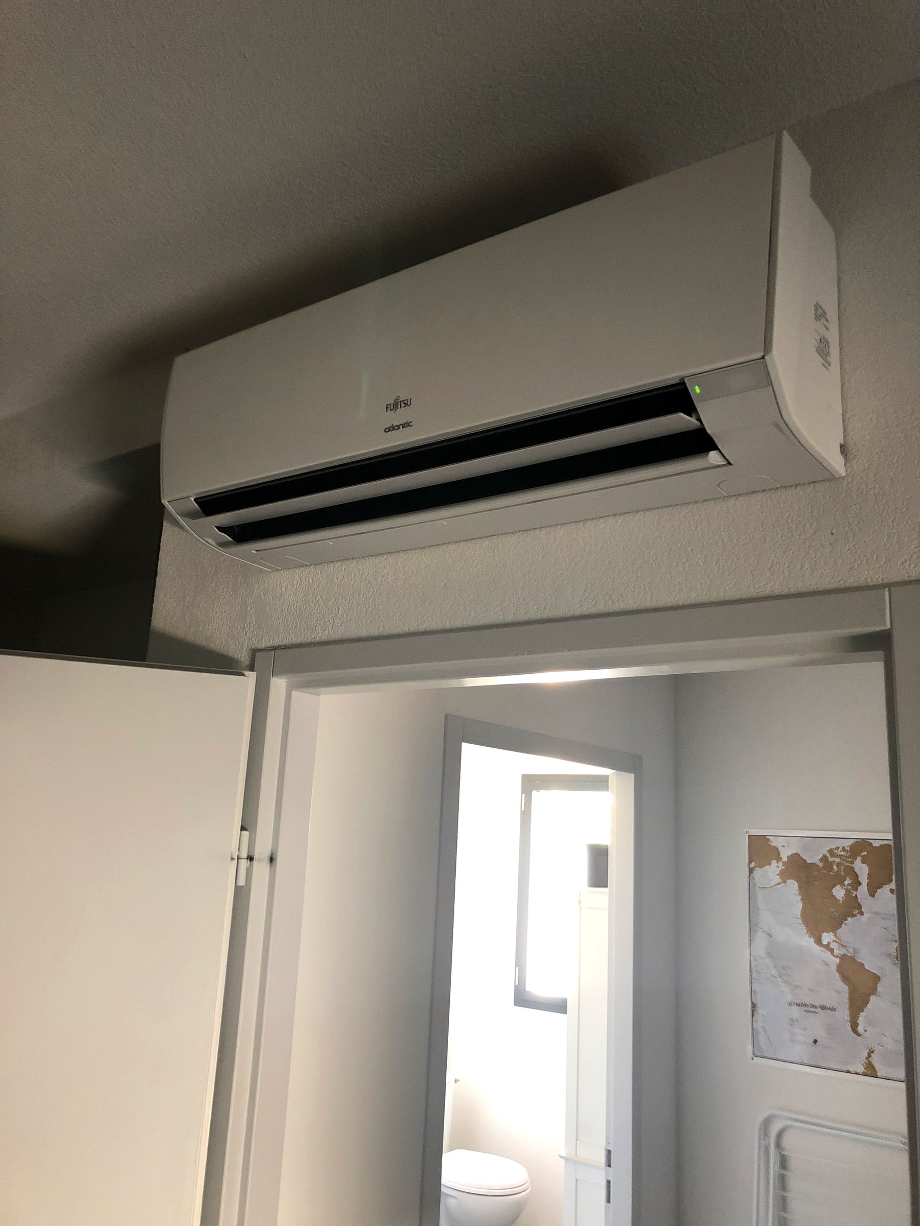 Unité intérieure murale de climatisation posée au-dessus d'une porte