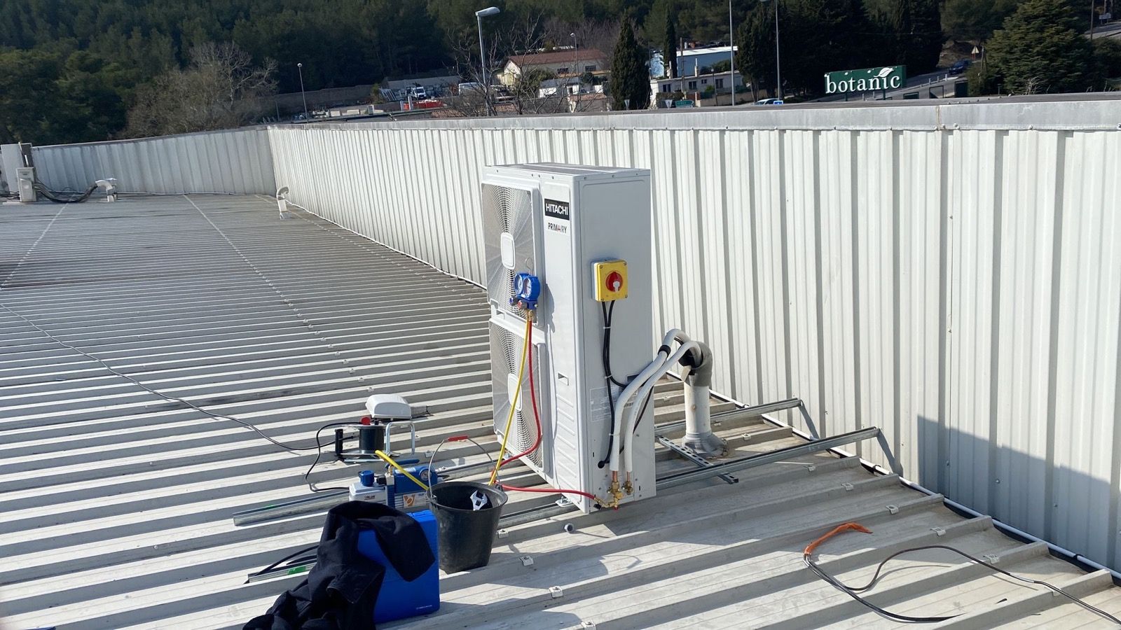 Toiture en bac acier avec coffret électrique et équipements de ventilation en cours de raccordement
