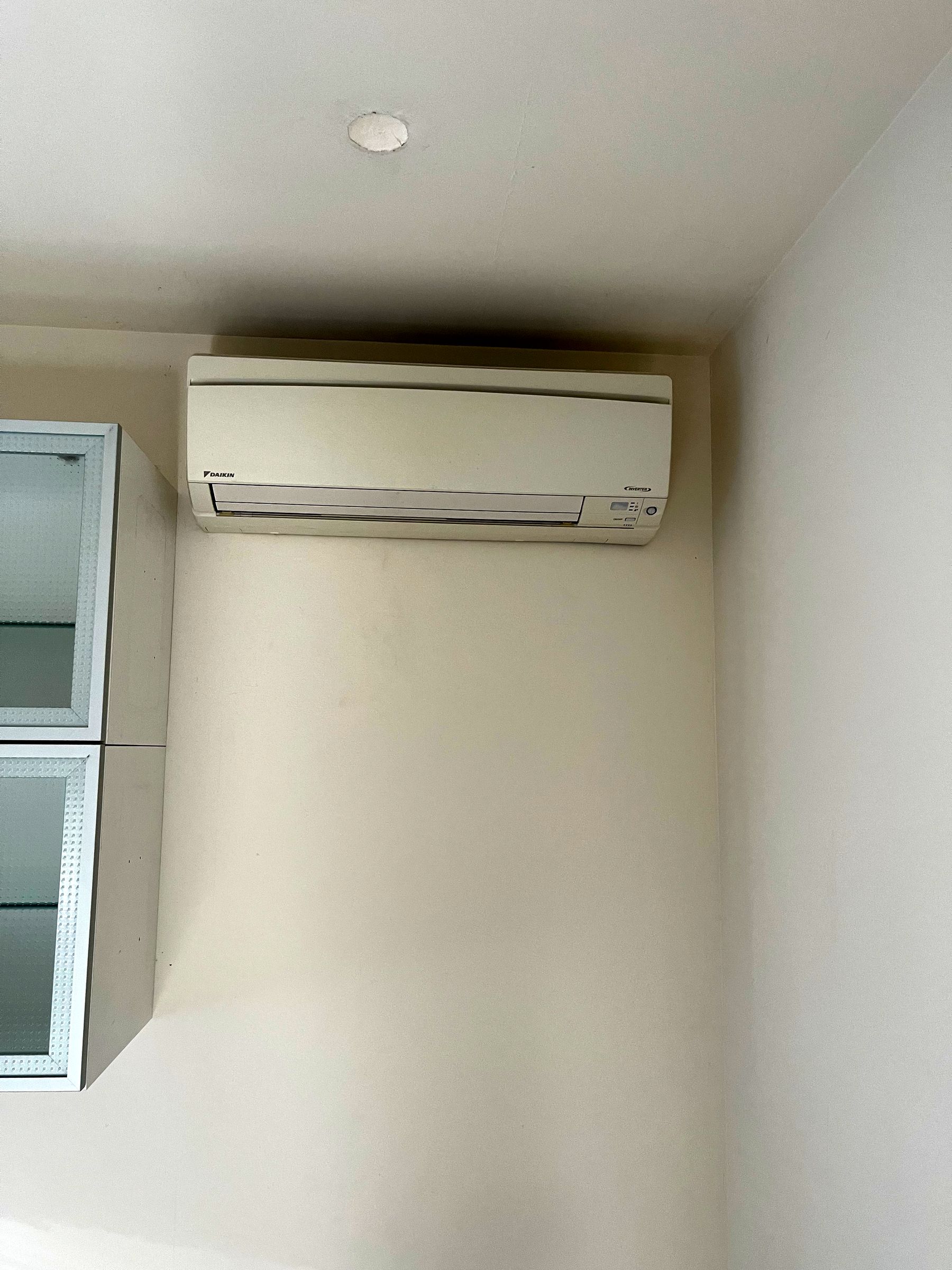 Unité intérieure murale de climatisation dans une pièce aux murs blancs
