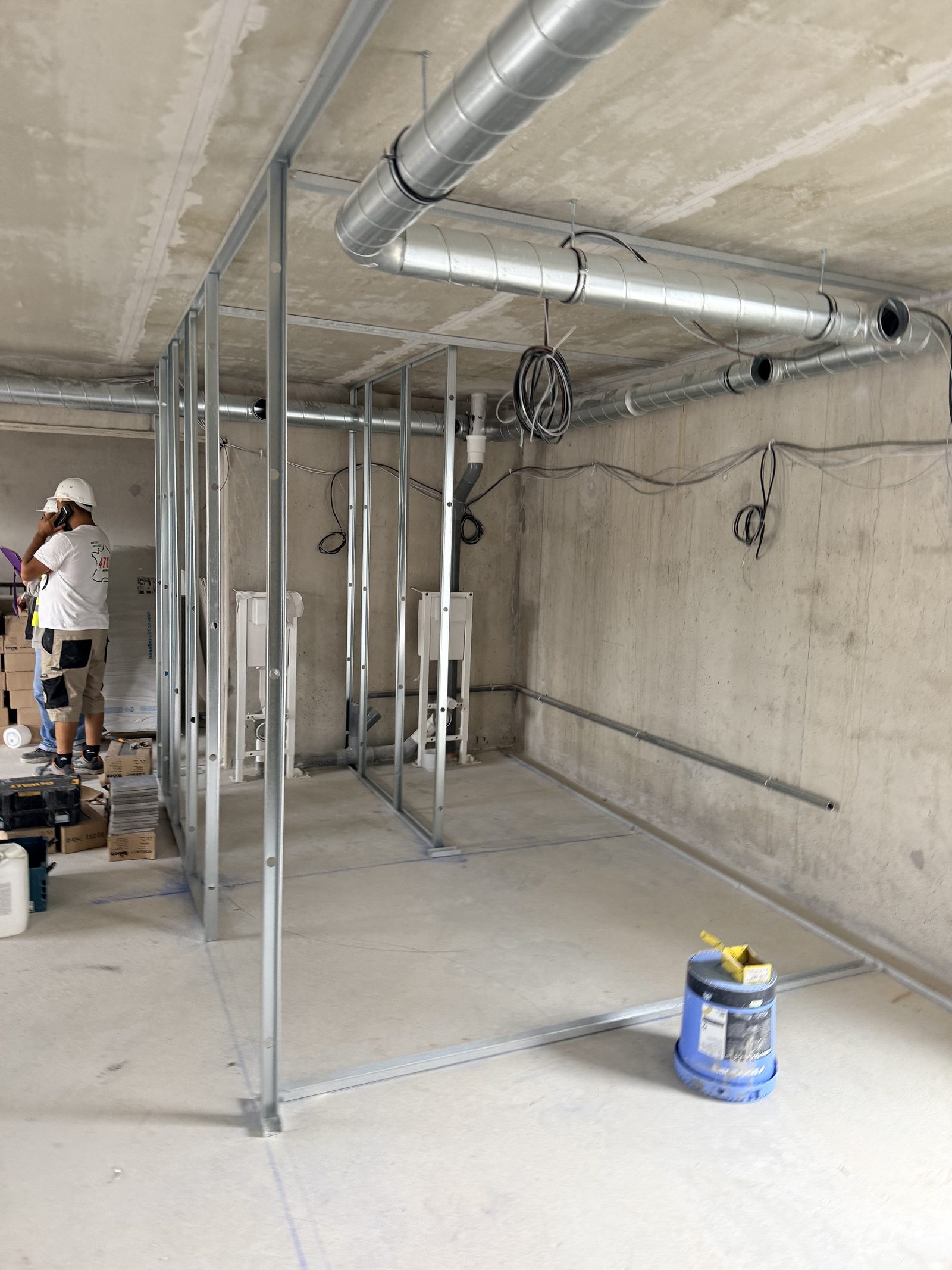 Réseau de gaines de ventilation spiralées en cours de pose dans un local tertiaire